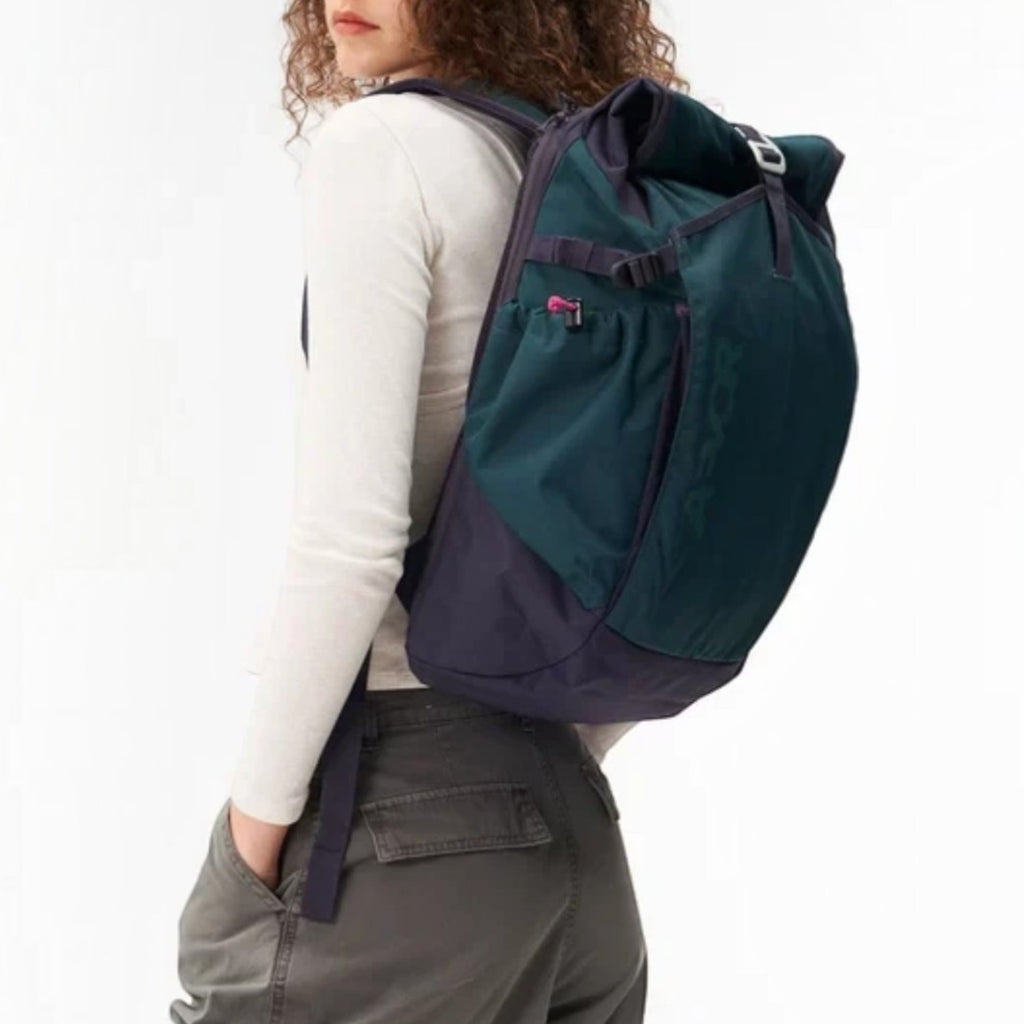 Lieblingstasche Roll Pack 2.0 backpack in dark green and navy with rolltop closure worn by a woman