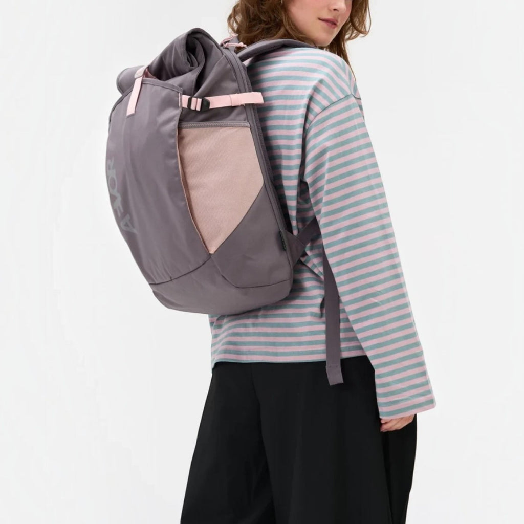 Lieblingstasche Roll Pack 2.0 grey backpack with pink accents worn by a woman in a striped long-sleeve shirt