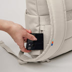 Lieblingstasche Rolltop Easy Small backpack in beige showing the hidden back pocket with a hand inserting a phone.