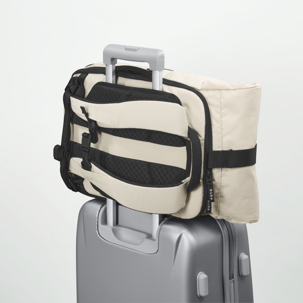 Lieblingstasche Rolly32 beige rolltop backpack attached to a silver suitcase trolley handle for travel