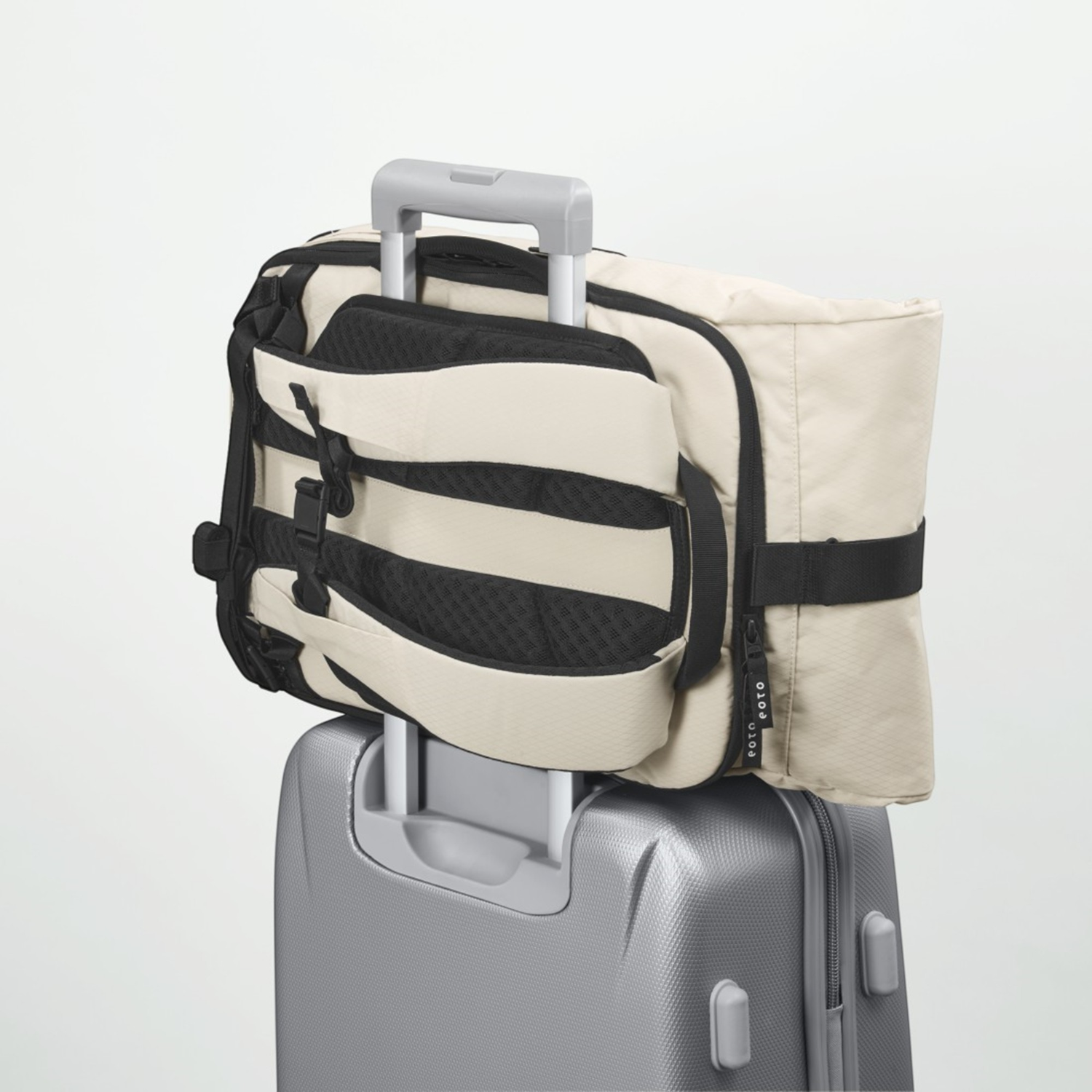 Lieblingstasche Rolly32 beige rolltop backpack attached to a silver suitcase trolley handle for travel