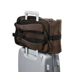 Lieblingstasche Rolly32 brown rolltop backpack attached to a silver suitcase trolley handle for travel