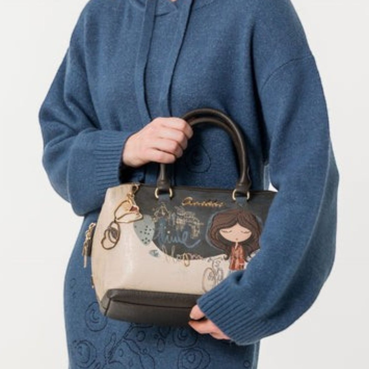 Lieblingstasche short handle bag with illustrated graphic design held by a woman in a blue knit sweater dress