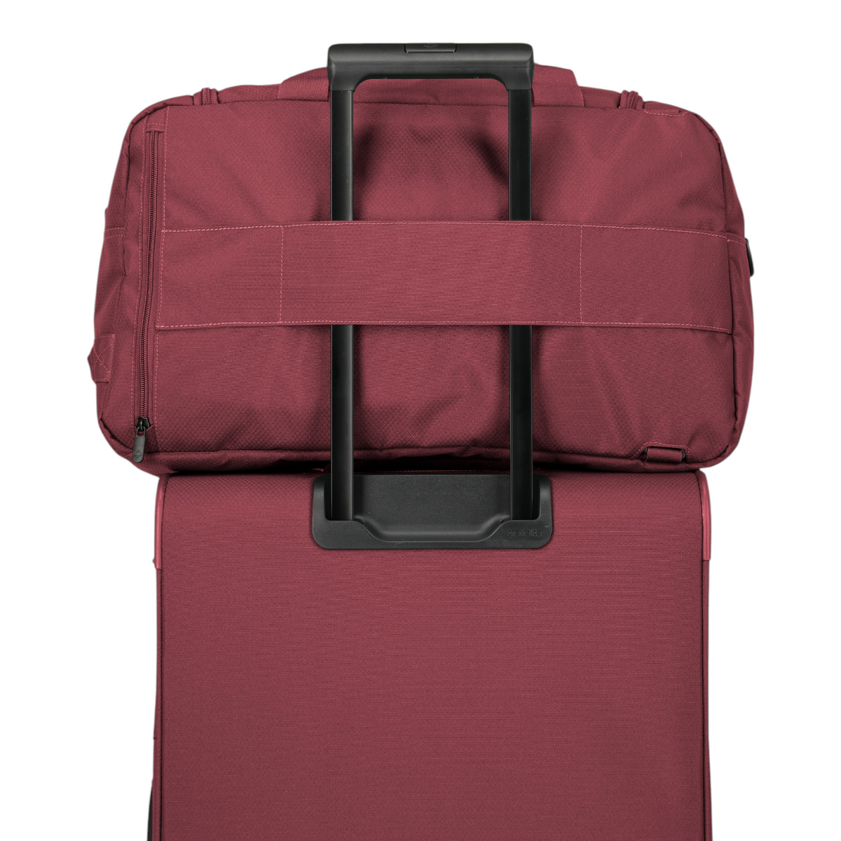 Lieblingstasche Skaii weekender bag in burgundy attached to a matching suitcase handle for easy travel.