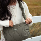 Lieblingstasche Skara Small Quilted bag in olive green with a soft ruched shoulder strap worn by a woman