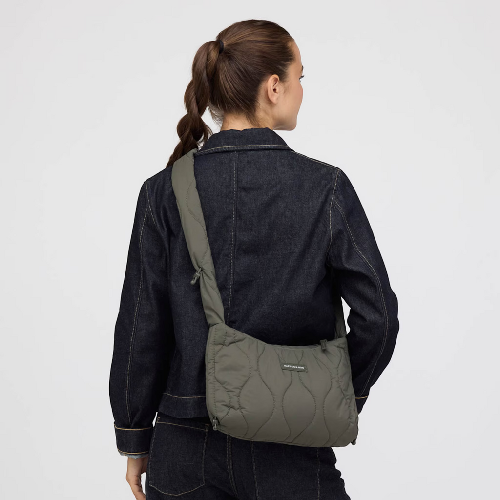 Lieblingstasche Skara Small Quilted olive green crossbody bag worn by a woman in a dark denim jacket