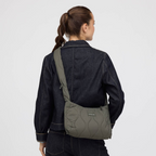 Lieblingstasche Skara Small Quilted olive green crossbody bag worn by a woman in a dark denim jacket