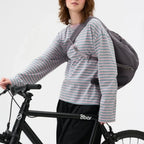 Lieblingstasche Slouchy Bag in grey worn as a crossbody bag by a woman on a bicycle