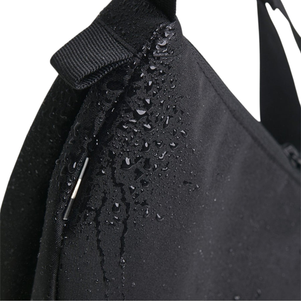 Lieblingstasche small black moon bag made of water-repellent fabric with water droplets.