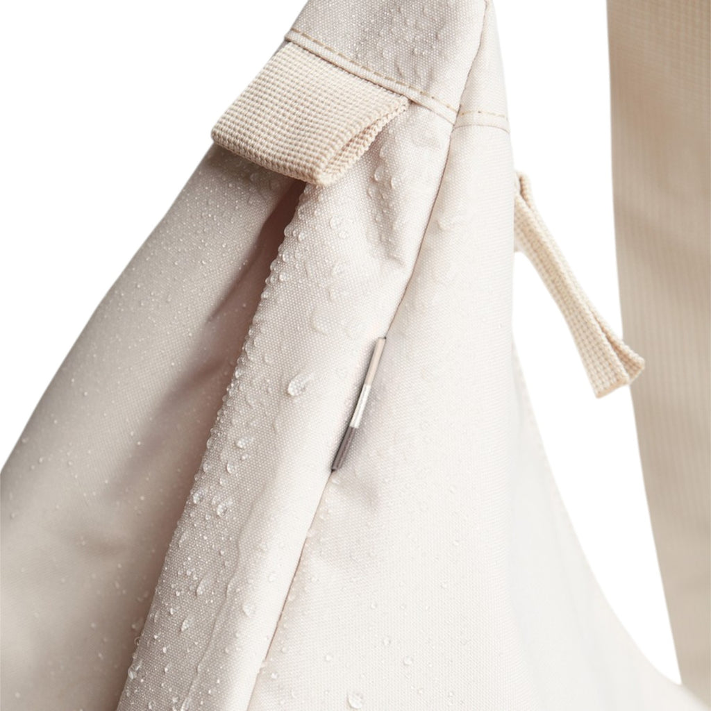 Lieblingstasche small moon bag in beige canvas with water droplets and a zippered pocket.