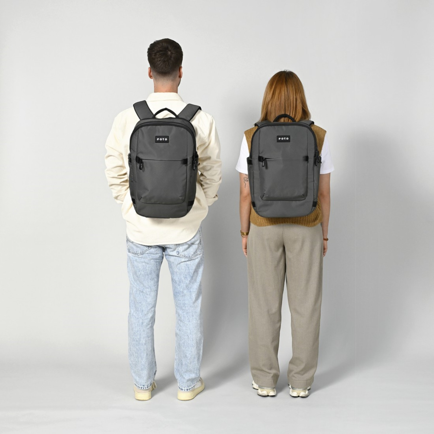 Lieblingstasche Tidy22 grey business laptop backpack worn by a man and woman against a neutral background
