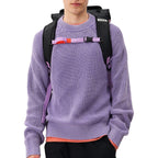 Lieblingstasche Trip Pack black backpack with purple straps worn by a man in a lavender sweater