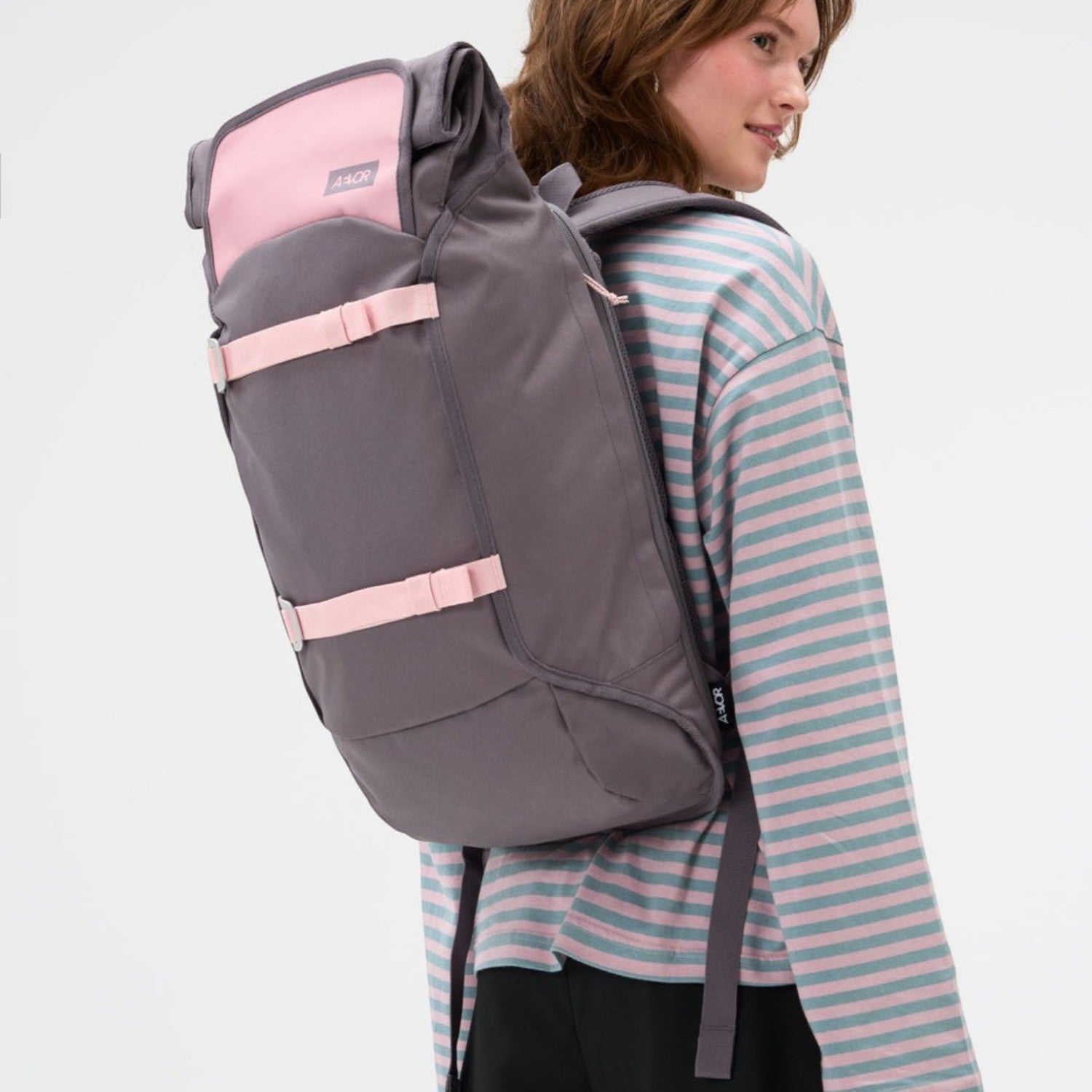 Lieblingstasche Trip Pack rolltop backpack in grey and pink with adjustable straps worn by a woman