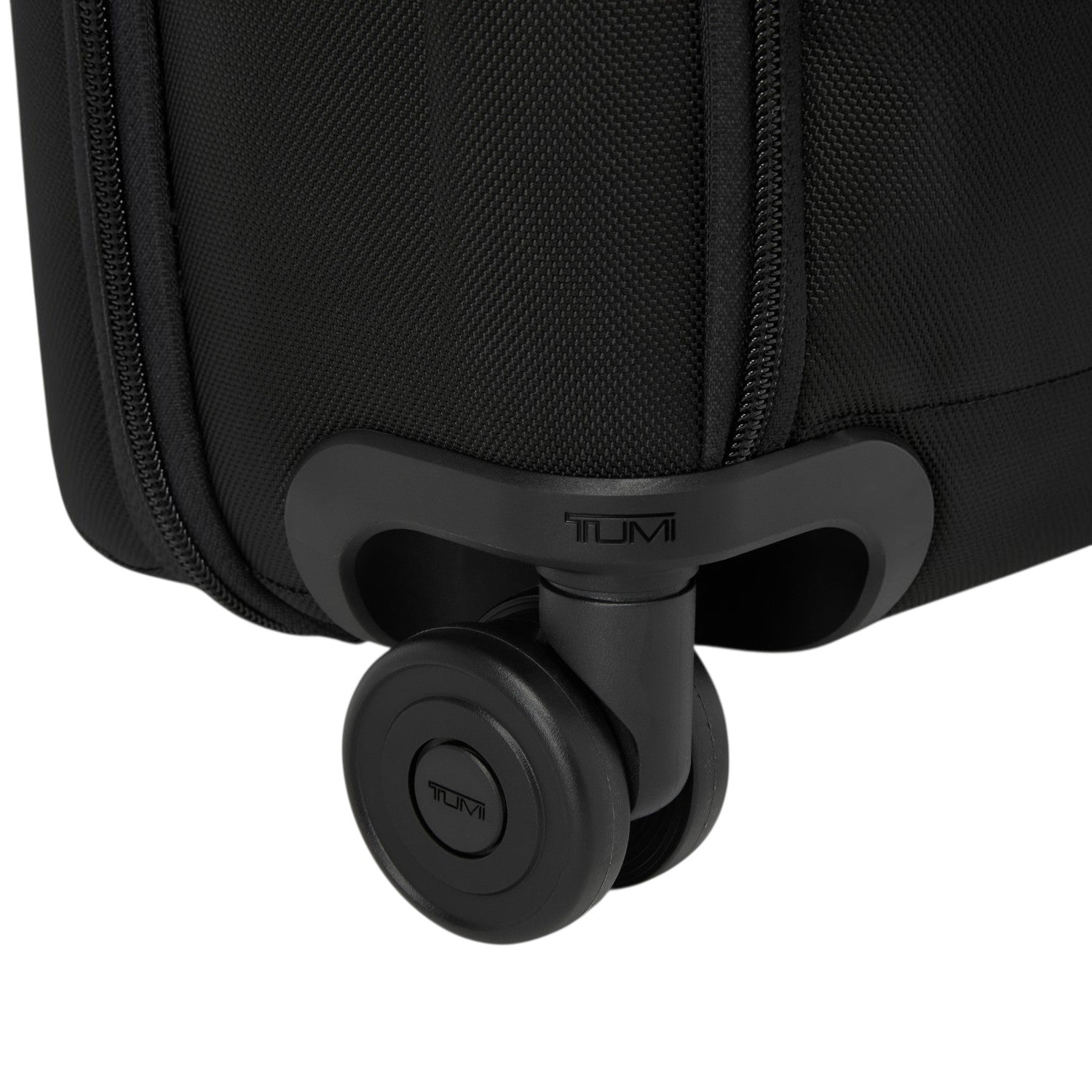 Close-up of the durable black wheel and Tumi logo on a Lieblingstasche Tumi Alpha Compact Carry On suitcase